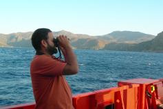 Beneharo Rodríguez, miembro de SEO BirdLife, observando las aves que pasan cerca del barco / Beneharo Rodríguez, member of the SEO BirdLife organization, is watching the birds passing next to the boat ©ICM-CSIC